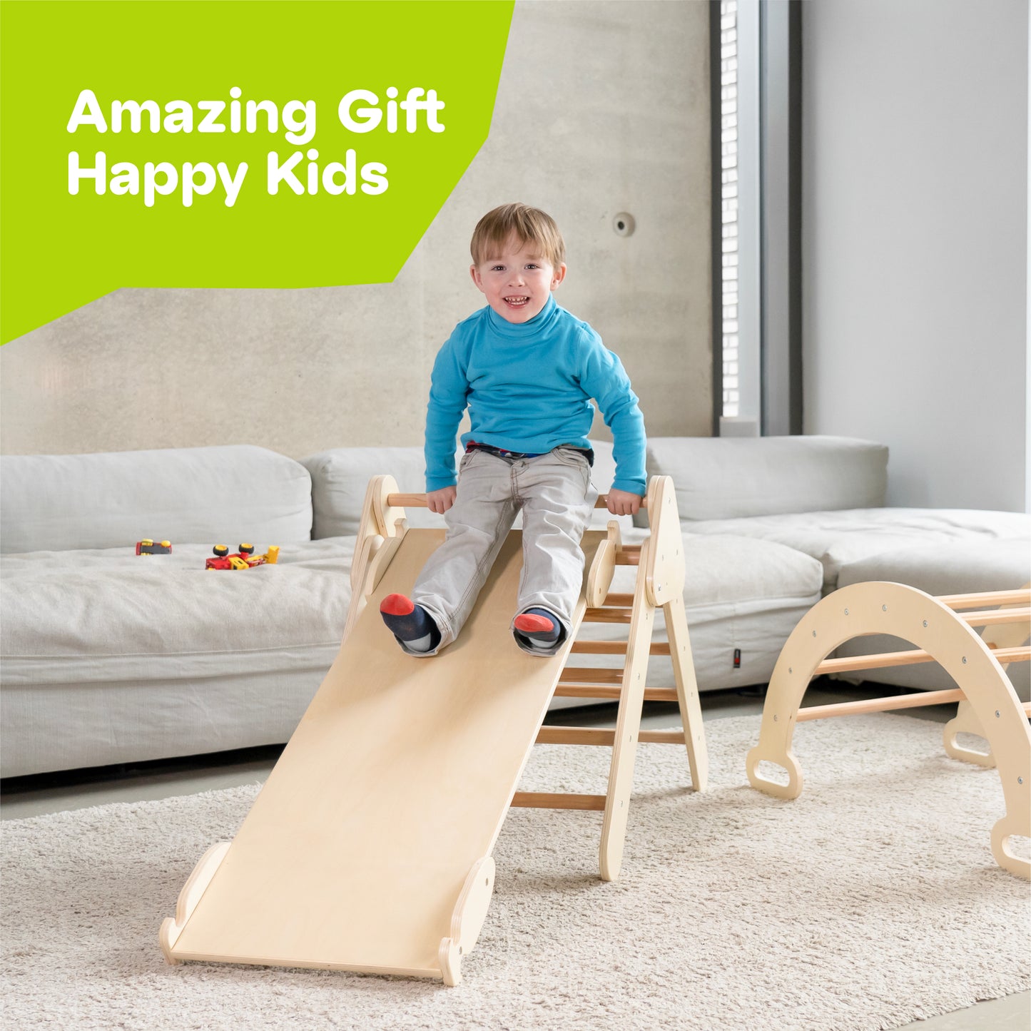 Kleiner Junge rutscht freudig auf einer stabilen Holzrampe eines Kletterdreiecks. Die Rampe ist sicher im Wohnraum platziert, ideal für spielerische Aktivitäten und motorische Entwicklung. Perfekt als Geschenk für glückliche Kinder.